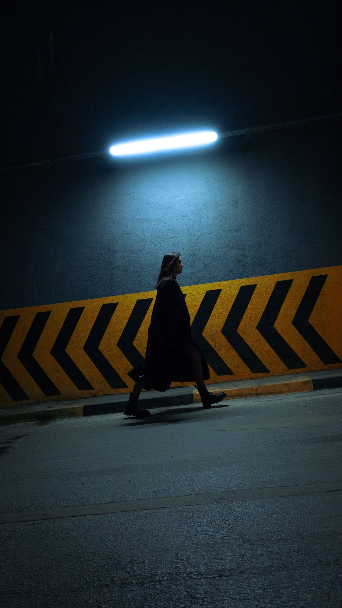 Look 04: Frau geht durch einen dunklen Tunnel