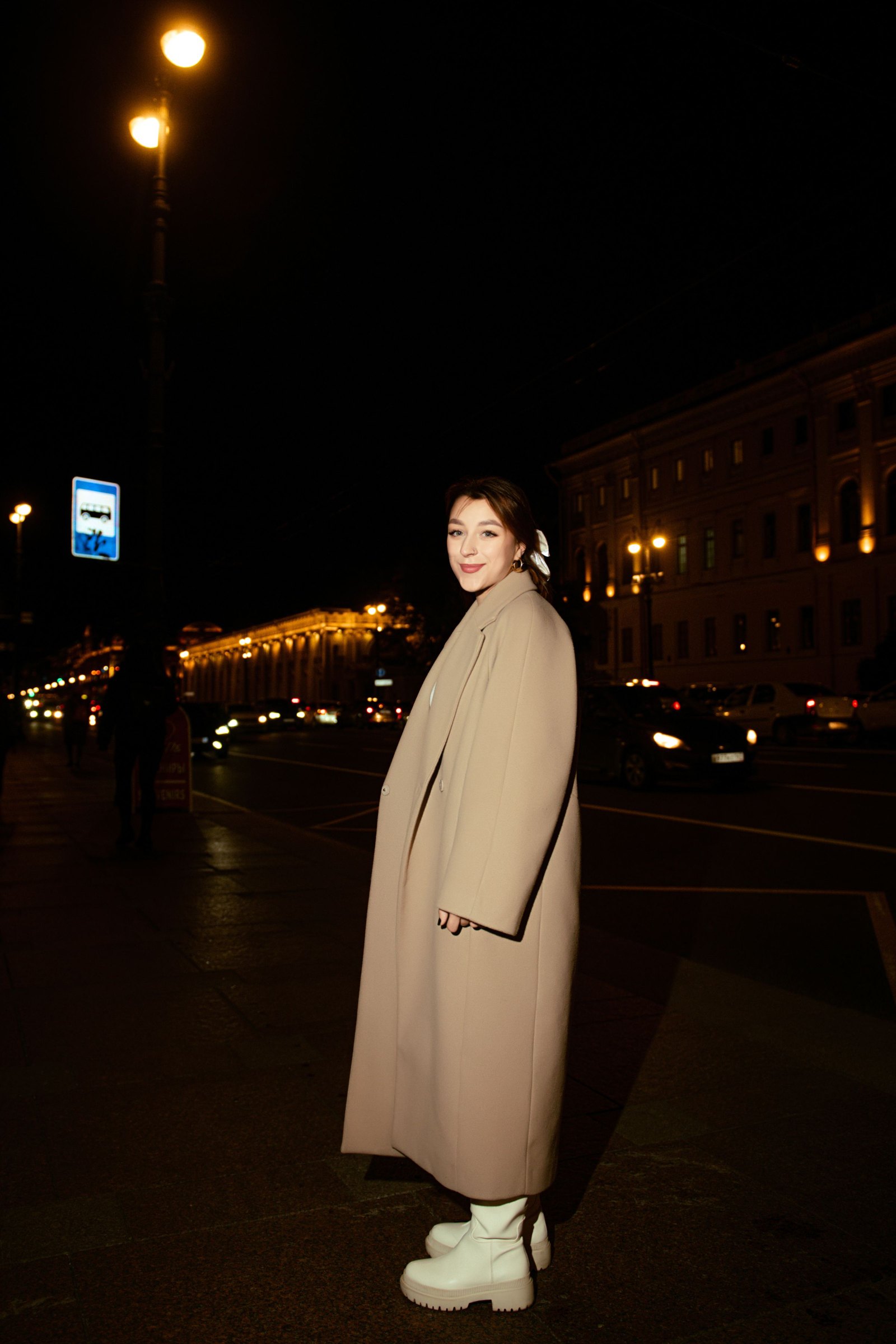 Look 03: Frau in beigem Trench nachts auf der Straße